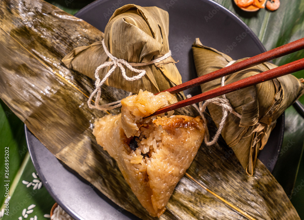 粽子，绿色餐桌背景下吃蒸饺的女人，端午节的食物