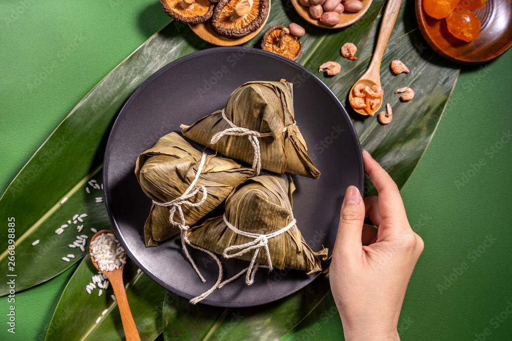 粽子，绿色餐桌背景下吃蒸饺的女人，端午节的食物