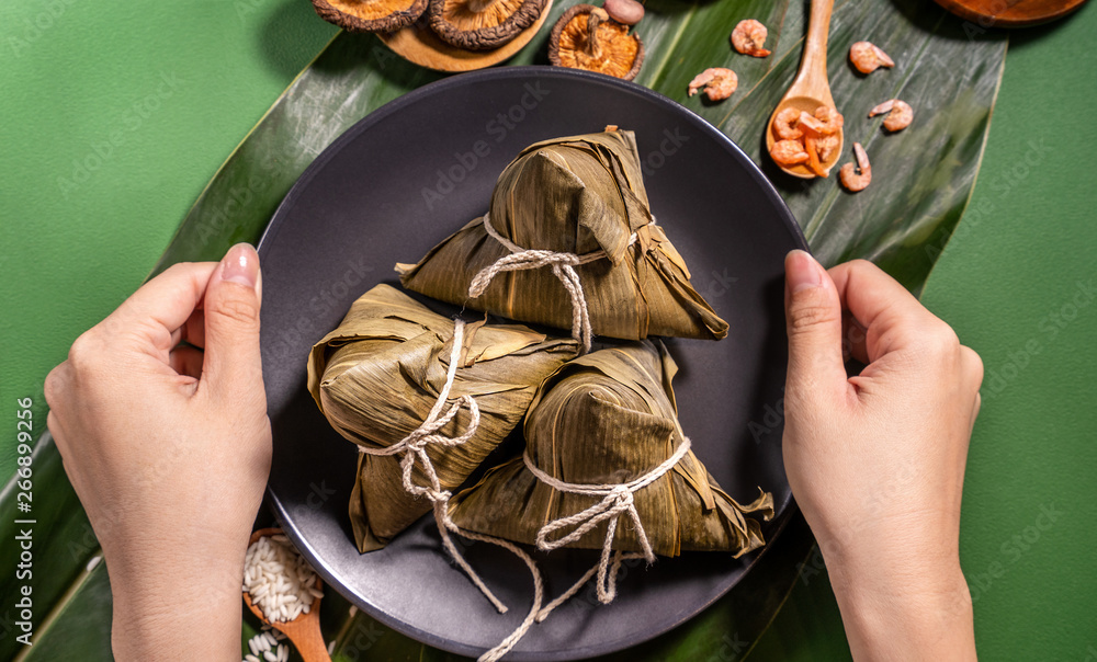 粽子，绿色餐桌背景下吃蒸饺的女人，端午节的食物