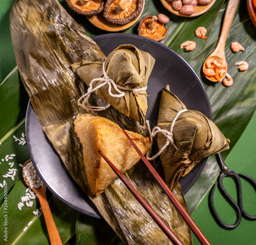 粽子，绿色餐桌背景下吃蒸饺的女人，端午节的食物