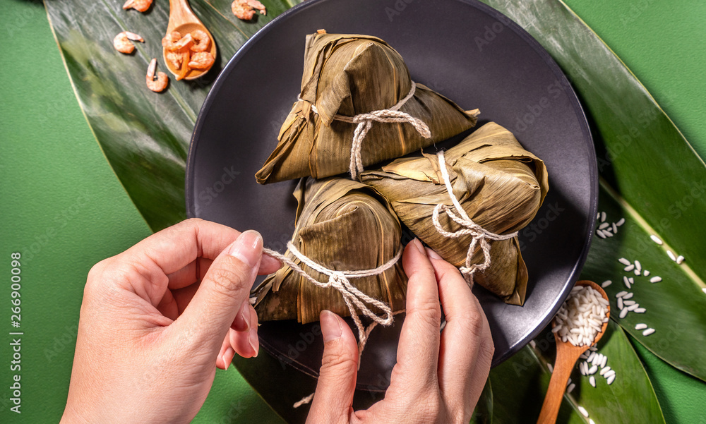 粽子，绿色餐桌背景下吃蒸饺的女人，端午节的食物