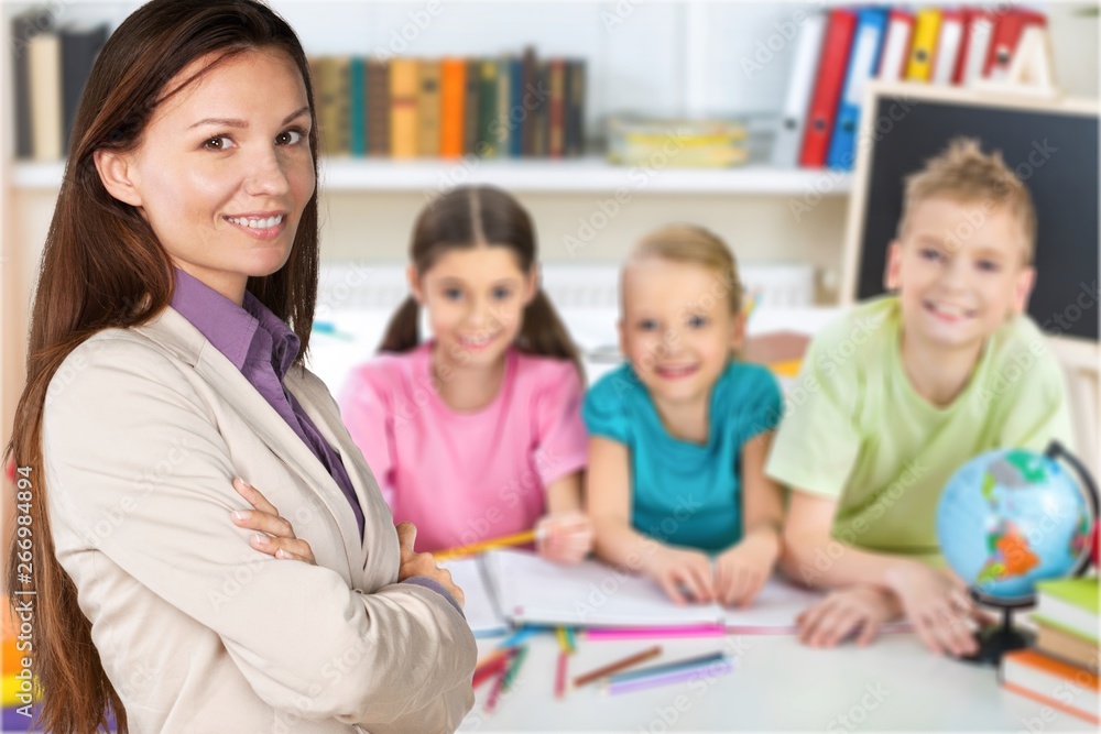 Friendly school children with books at class