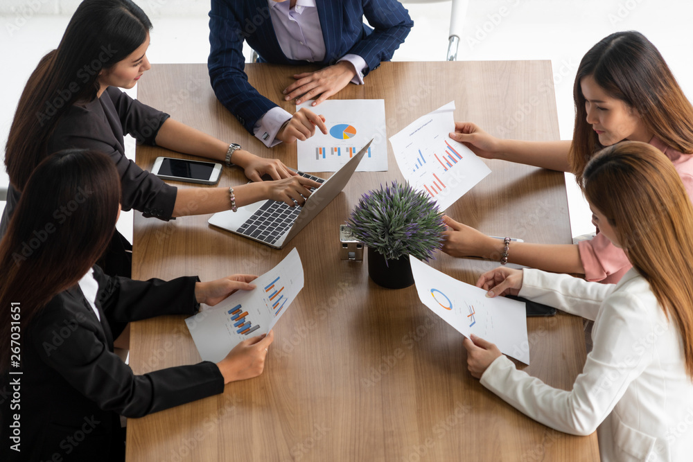 Businesswoman in group meeting discussion with other businesswomen colleagues in modern workplace of