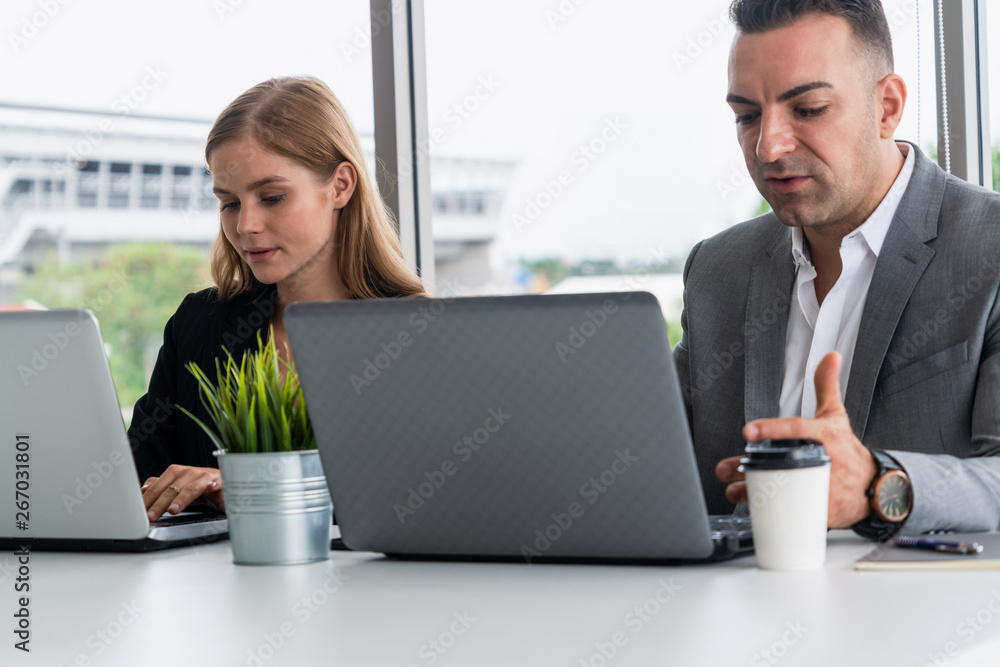 Businessman executive is in meeting discussion with a businesswoman worker in modern workplace offic