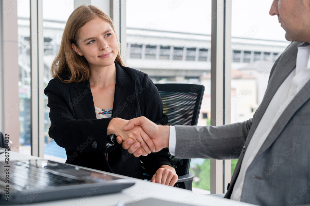 Businessman executive handshake with businesswoman worker in modern workplace office. People corpora