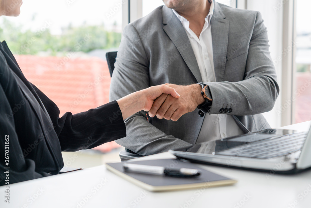 Businessman executive handshake with businesswoman worker in modern workplace office. People corpora