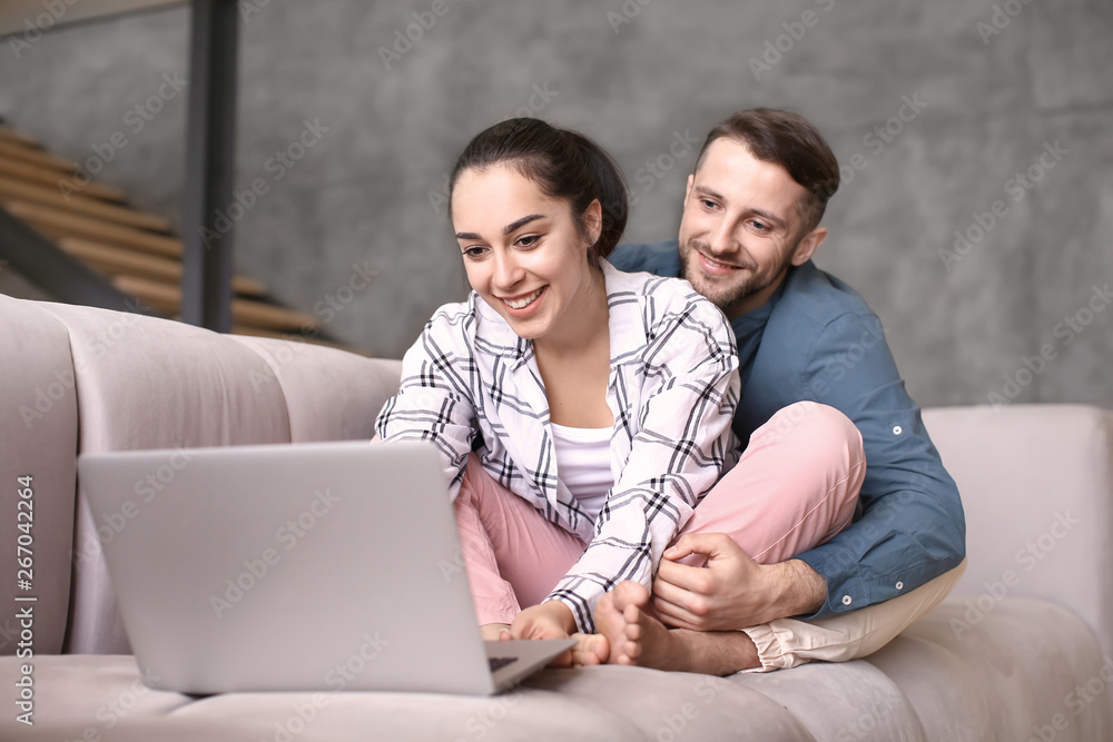 Happy young couple with laptop at home