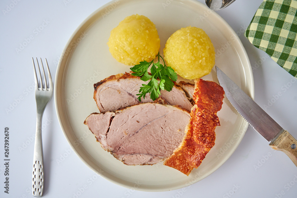 Deutscher Schweinebraten mit Kruste und Knödel auf weißem Hintergrund top view restaurant