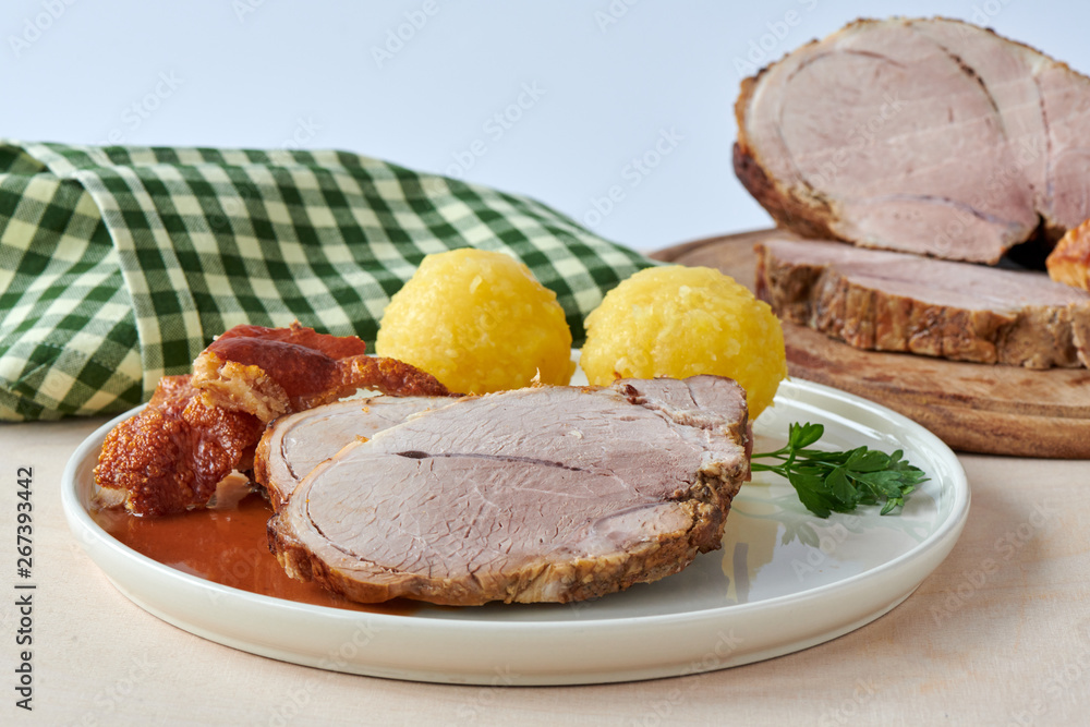 Deutscher Schweinebraten mit Kruste und Knödel auf weißem Hintergrund 