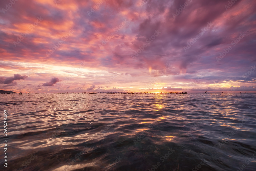 日出时的海景。夏天的天空和水面上的倒影。太阳时的阳光