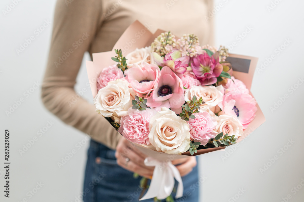 Beautiful bouquet of mixed flowers in woman hand. the work of the florist at a flower shop. Delicate