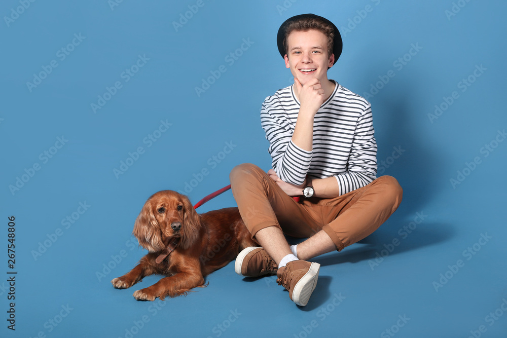 Teenage boy with cute dog on color background