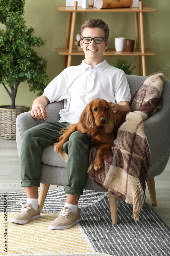 Teenage boy with cute dog at home