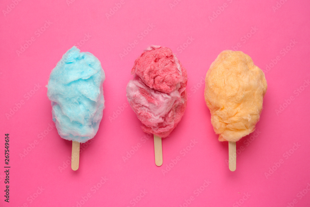 Tasty cotton candy on color background