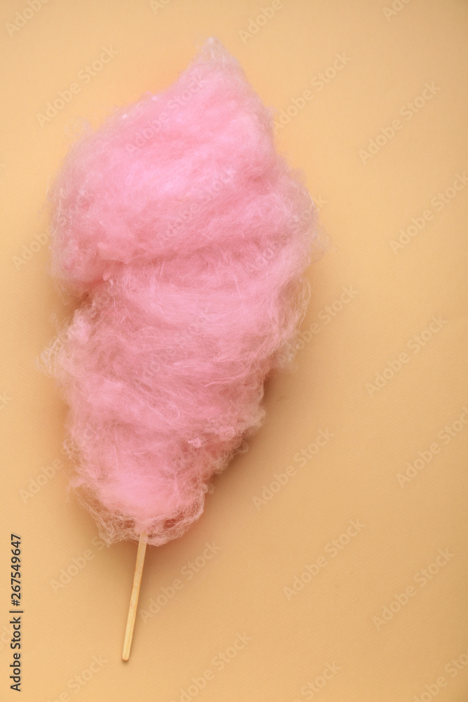 Tasty cotton candy on color background