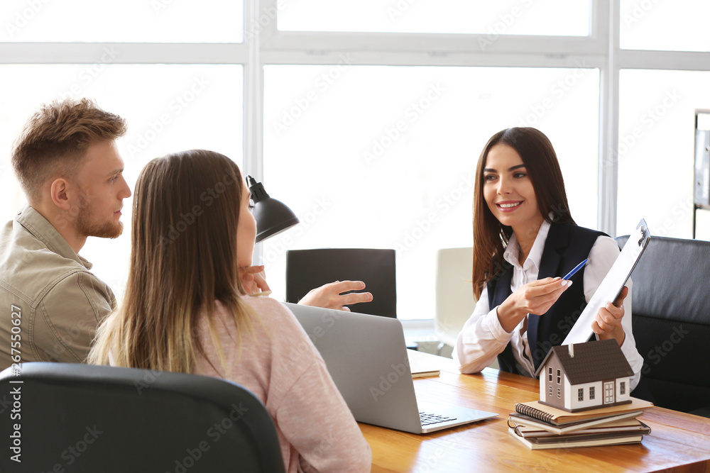 Young couple in office of real estate agent