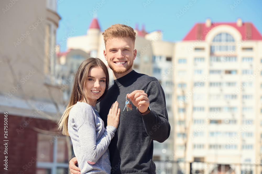 带钥匙的年轻夫妇在他们的新房子附近的户外