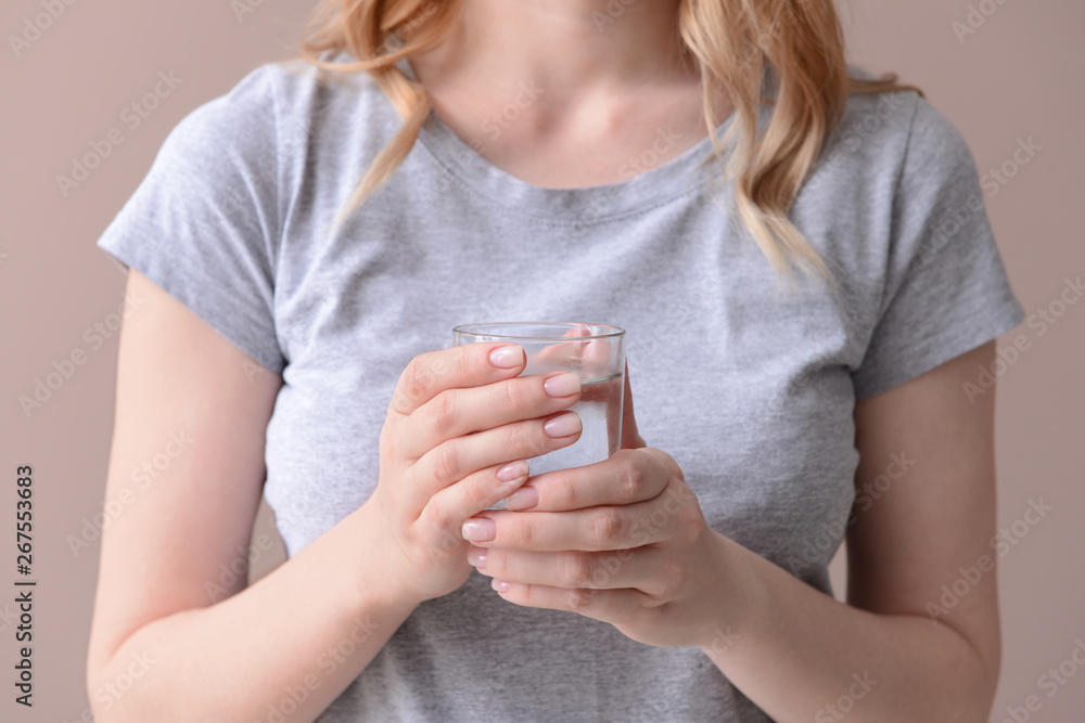 Woman with glass of fresh water on color background, closeup