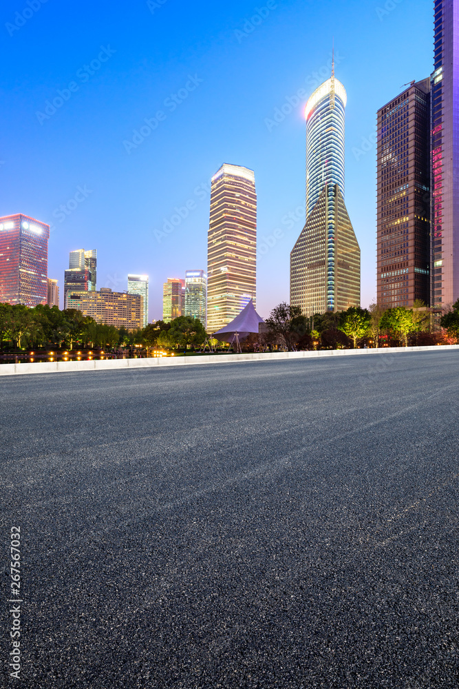 Shanghai modern commercial office buildings and empty asphalt highway at night