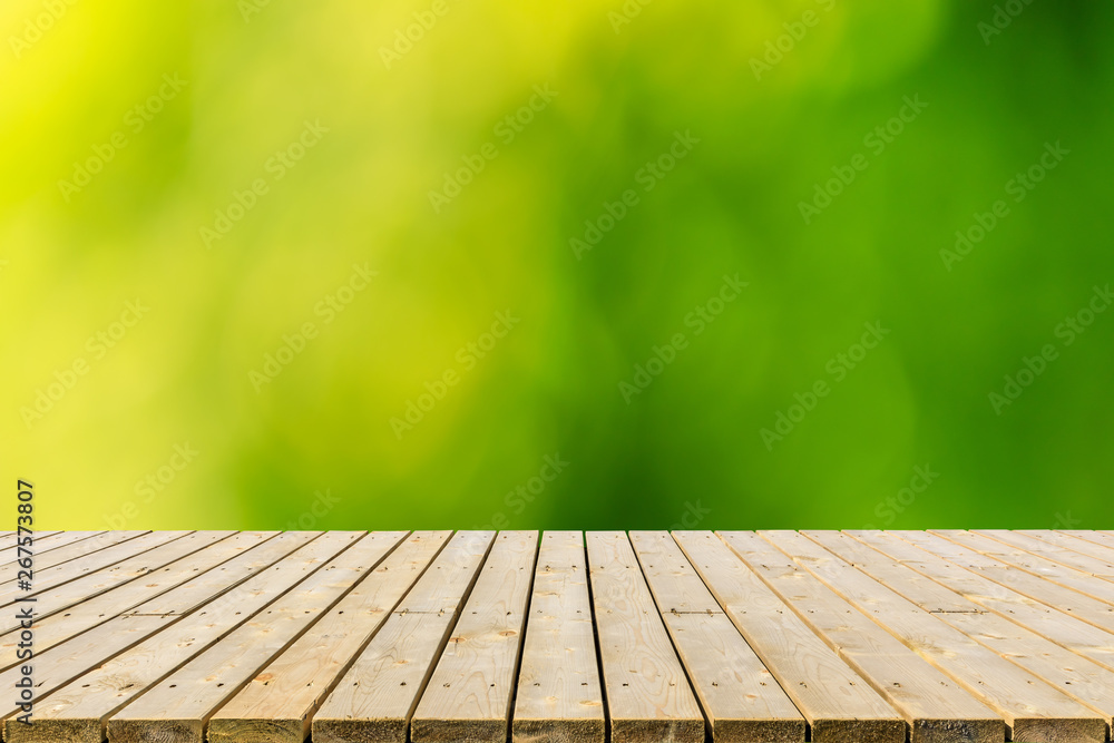 Empty wood plank table top with blur park green nature background