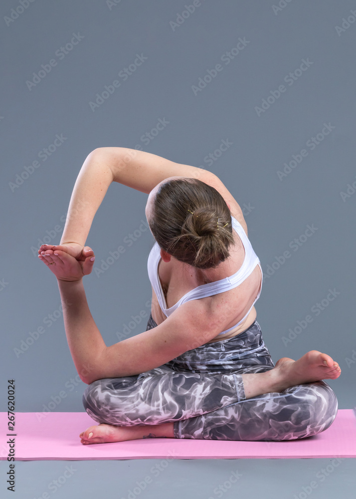 Beautiful sporty fit young woman practices yoga asana.