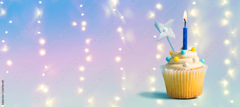 Celebratory cupcake with a decorative lit candle