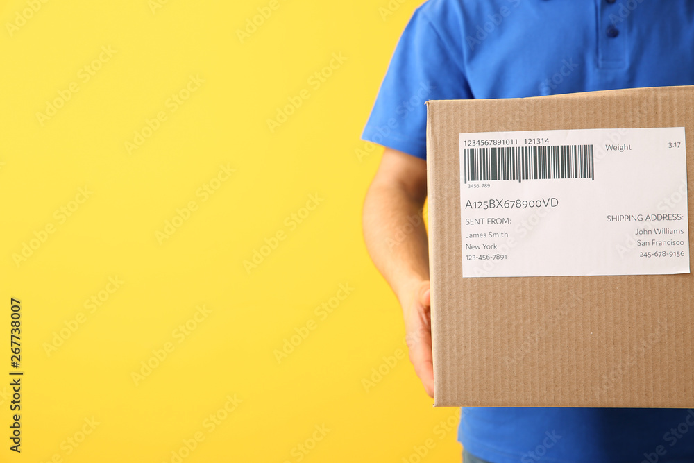 Delivery man with box on color background, closeup