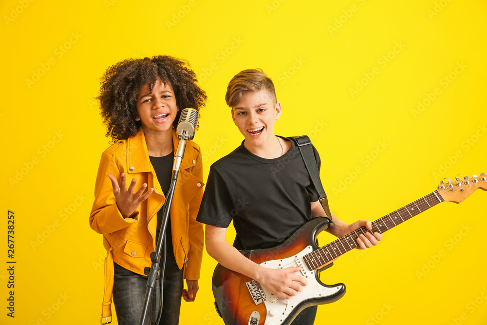 Teenage musicians playing against color background