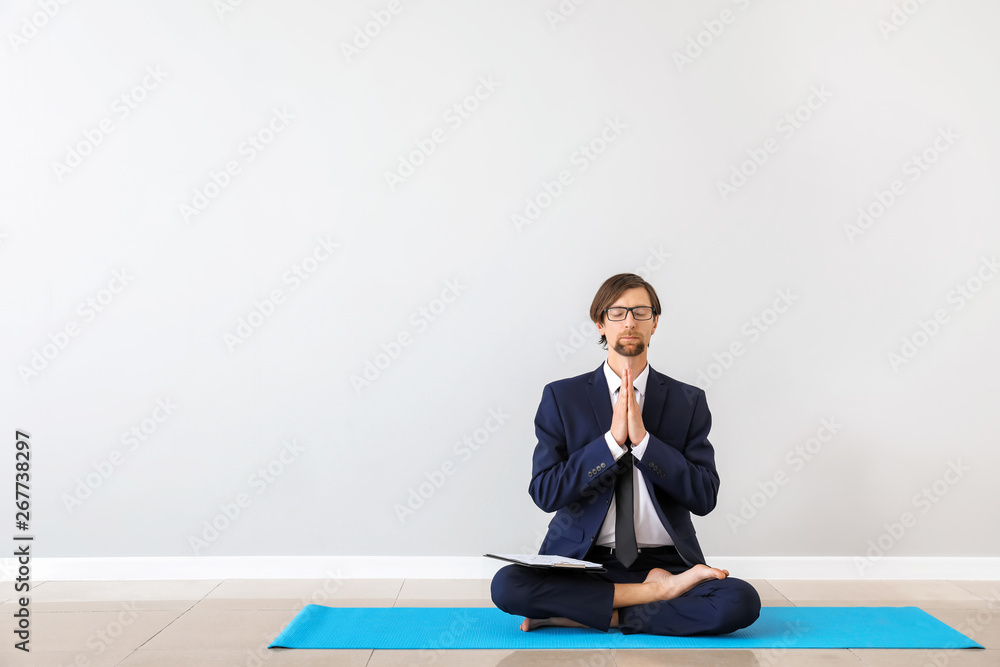 Businessman practicing yoga indoors