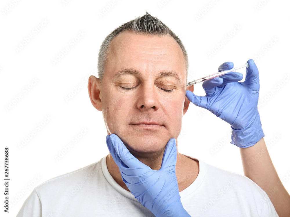 Middle-aged man and hands holding syringe for anti-aging injections on white background