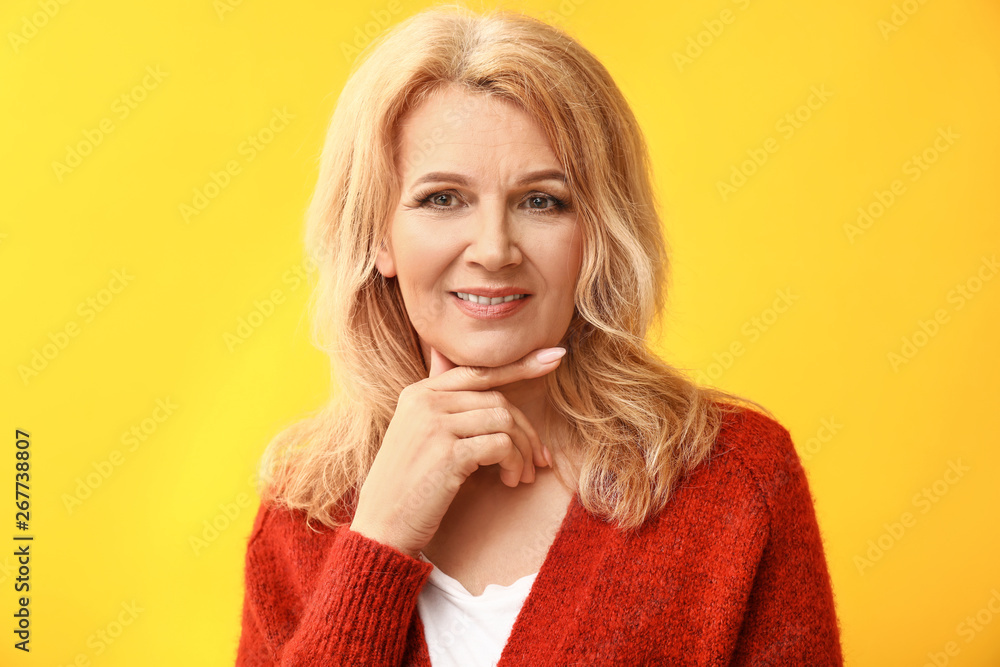 Portrait of beautiful mature woman on color background