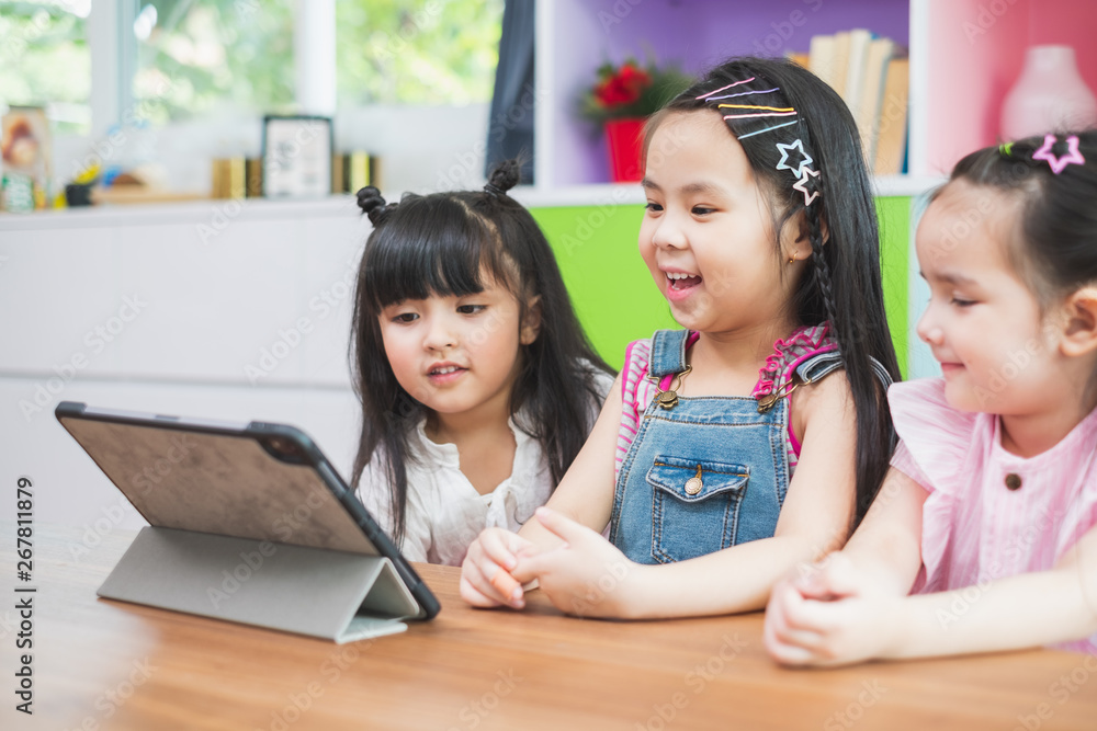 Group of diversity cute kids watching on tablet for lesson in classroom, education concept