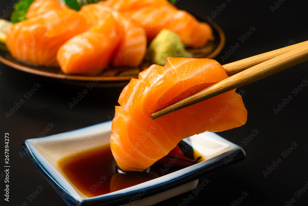 Sashimi, Salmon, Japanese food chopsticks and wasabi on the wood table