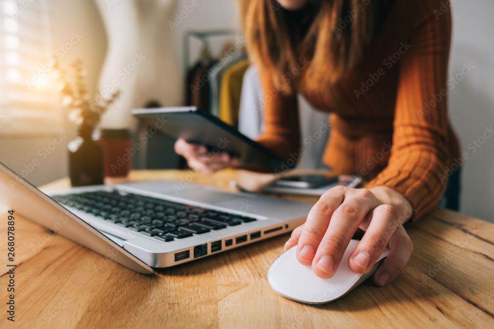  Fashion designer woman talking smart phone and using laptop with digital tablet computer in modern 