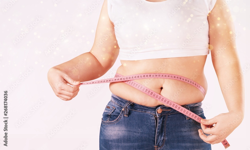 Fat woman measuring her stomach with tape