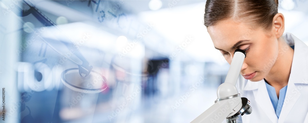 Young female scientist standing  on background