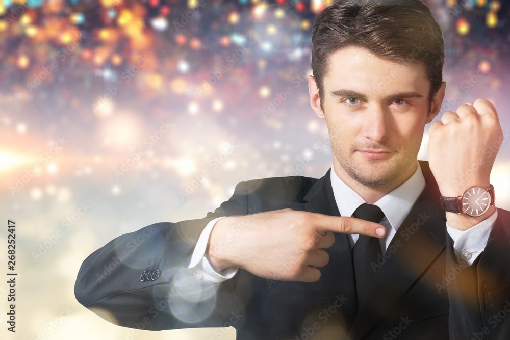 Businessman pointing at hand watch on  background