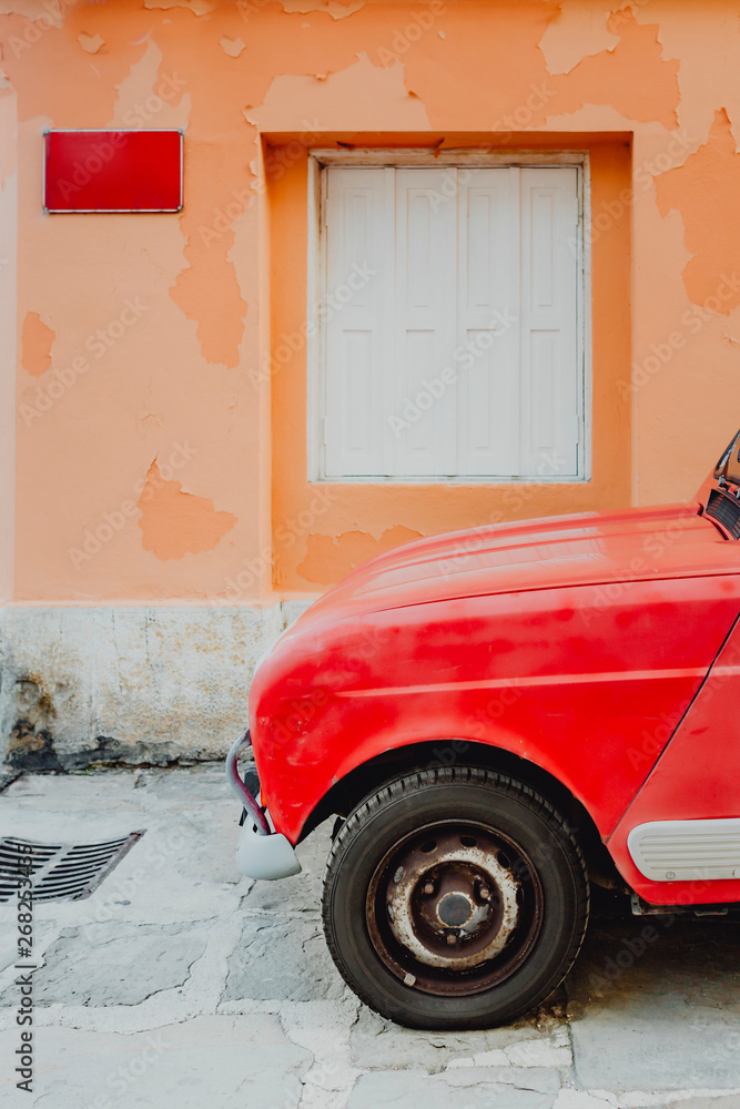 Red car by orange wall