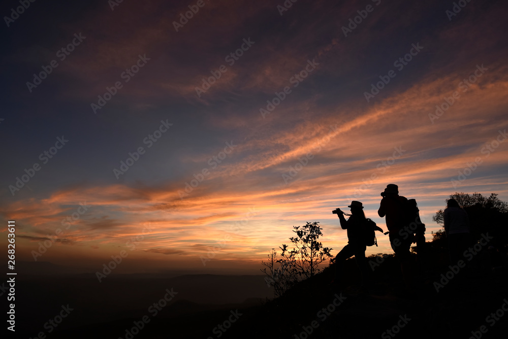 Two photographers silhouette are standing on a cliff with colorful twilight sky in an evening, Thail