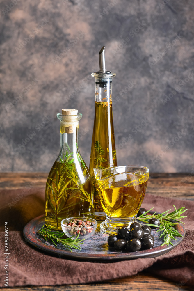 Plate with tasty olive oil and spices on table