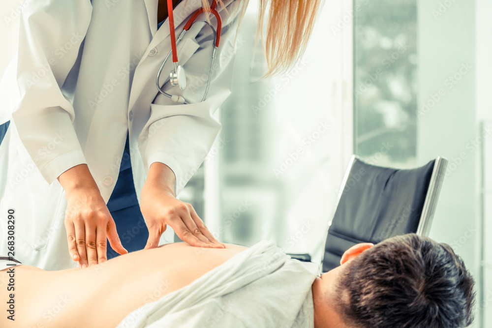 Woman doctor is examining male patient in hospital office. Healthcare and medical service.