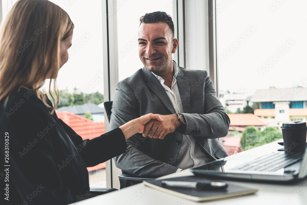 Businessman executive handshake with businesswoman worker in modern workplace office. People corpora