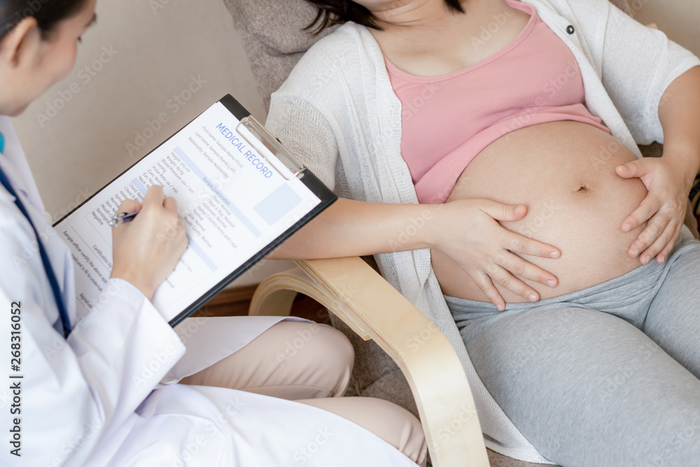 Happy pregnant woman visit gynecologist doctor at hospital or medical clinic for pregnancy consultan