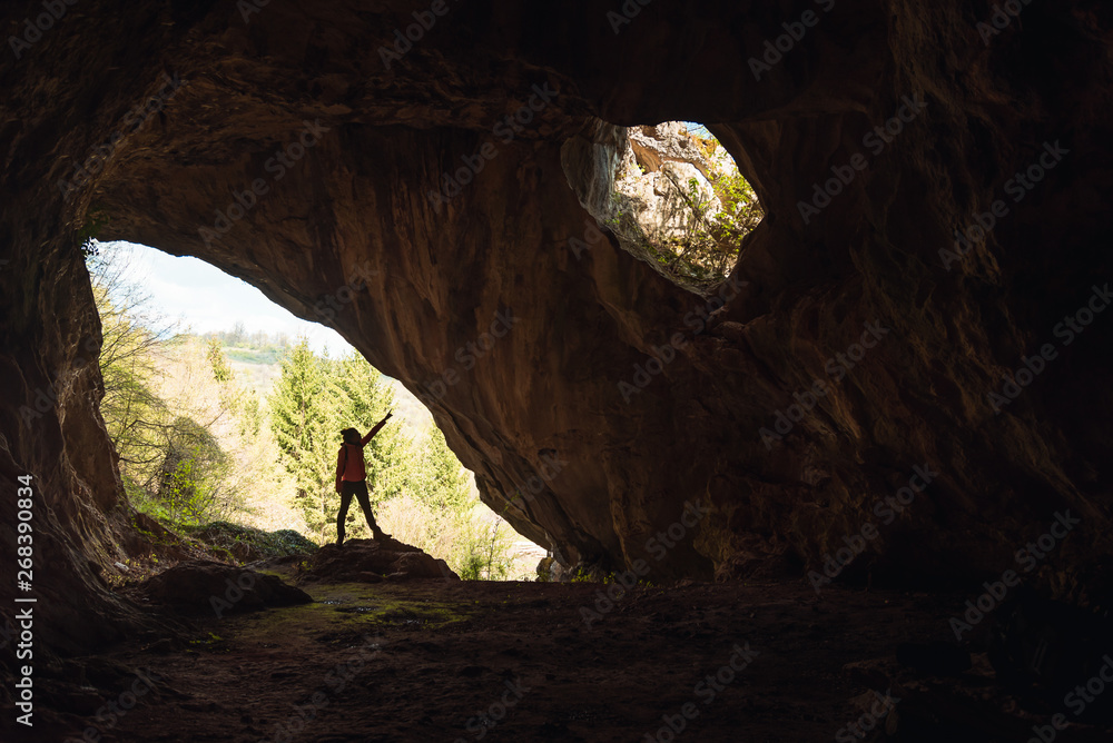 Girl in the entrance of a cave