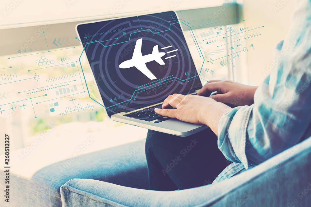 Airplane travel theme with woman using her laptop in her home office