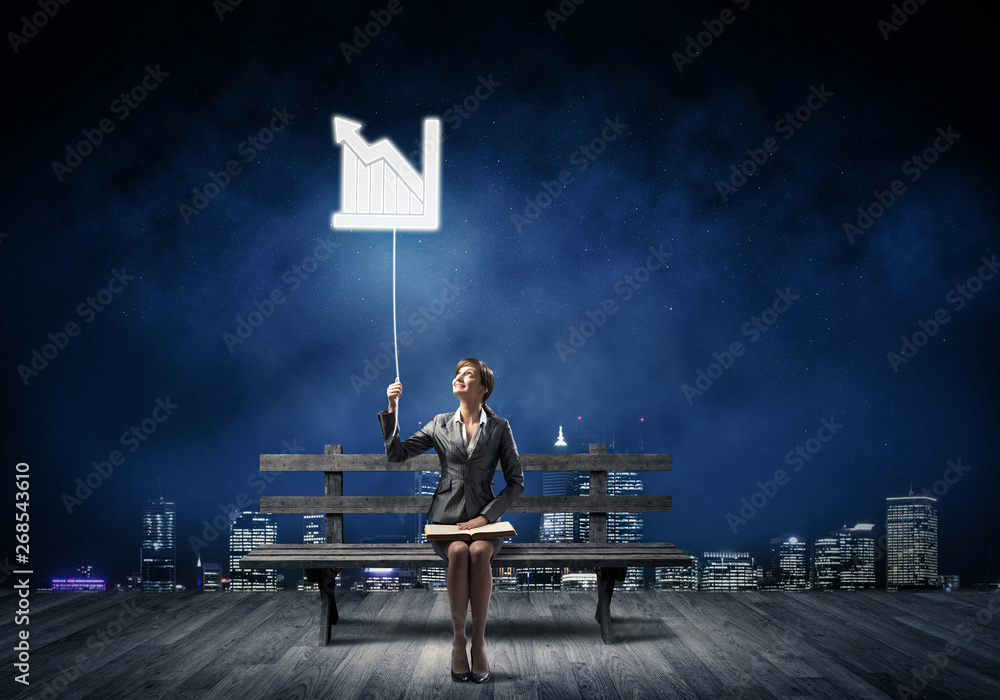 Young woman with open book on wooden bench