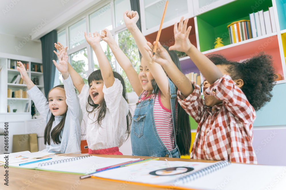 Group of little preschool kids hands up in class . portrait of children diversity education concept.