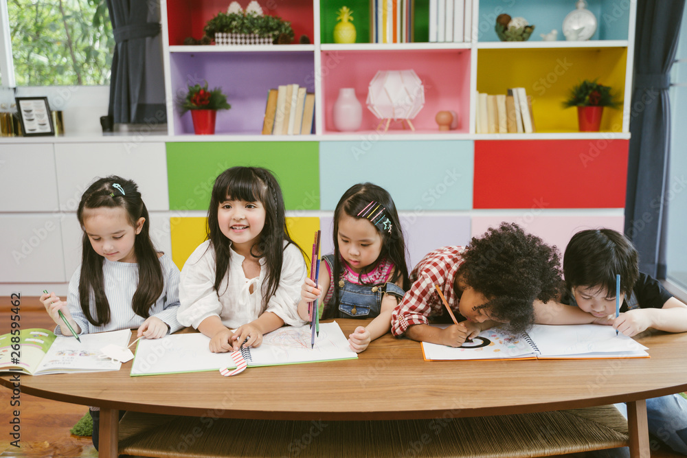 Group of little preschool kids drawing paper with color pencils . portrait of children friends educa