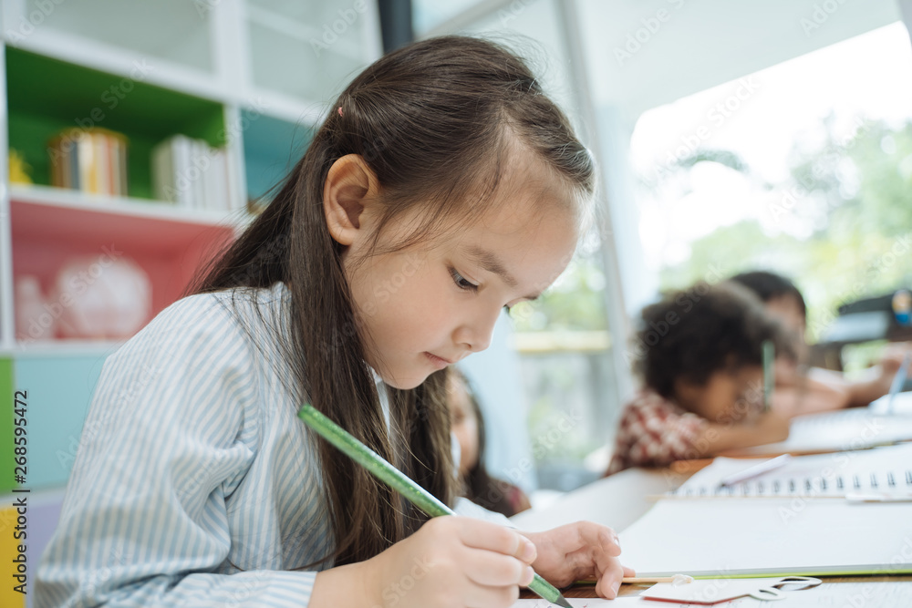 学龄前儿童用彩色铅笔画画。女孩与朋友的肖像教育骗局