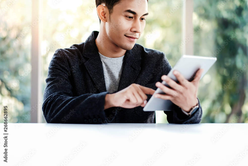 Happy Businessman Working on Digital Tablet in Office. Sitting at the Desk and Smiling. Selective Fo